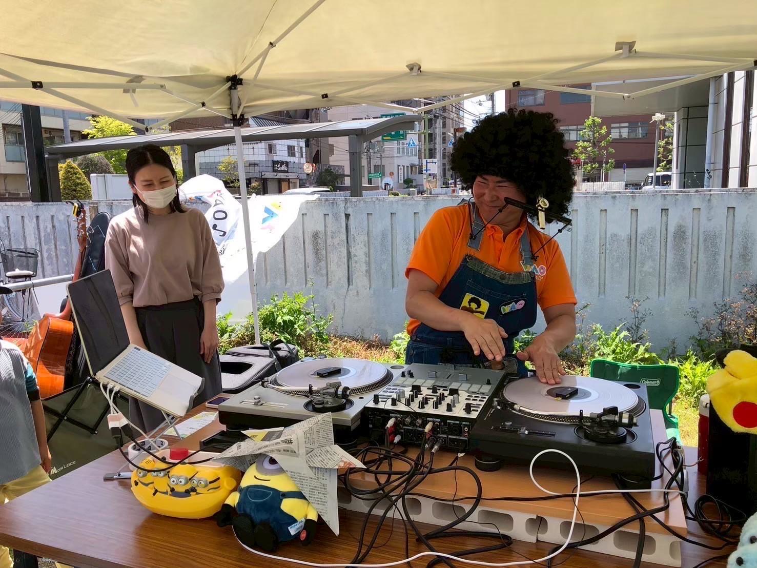 屋外イベントのテントでDJパフォーマンスをするメンバー